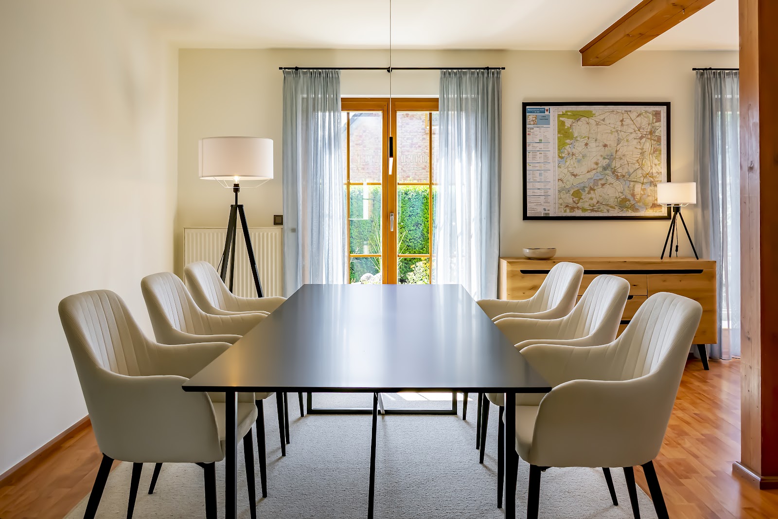 Modern eingerichtetes Esszimmer mit hellem Wandanstrich, dunklem Esstisch und beigen Stühlen.